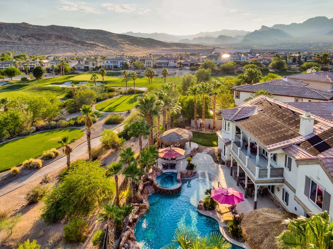 Aerial view of a Summerlin backyard pool and golf course with Red Rock mountains rising behind
